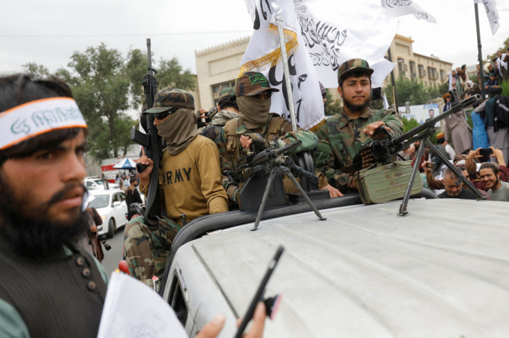 Taliban fighters rejoice on the first anniversary of the fall of Kabul on a street in Kabul