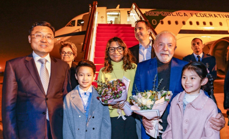 This handout picture released by the Brazil's Presidency shows Luiz Inacio Lula da Silva (R) posing for a picture with China's Vice Foreign Minister Xie Feng (L) after arriving in Shanghai on April 12