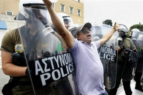 A protester pushes against a police cordon guarding the Greek parliament in central Athens