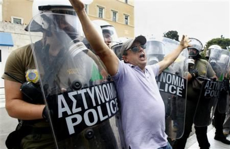 A protester pushes against a police cordon guarding the Greek parliament in central Athens