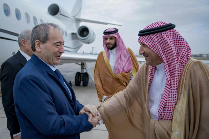 Saudi Deputy Foreign Minister Waleed al-Khuraiji (R) receives Syrian Foreign Minister Faisal Mekdad on his arrival in Jeddah
