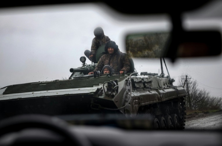 Ukrainian servicemen ride an infantry fighting vehicle on a road near Bakhmut in eastern Ukraine