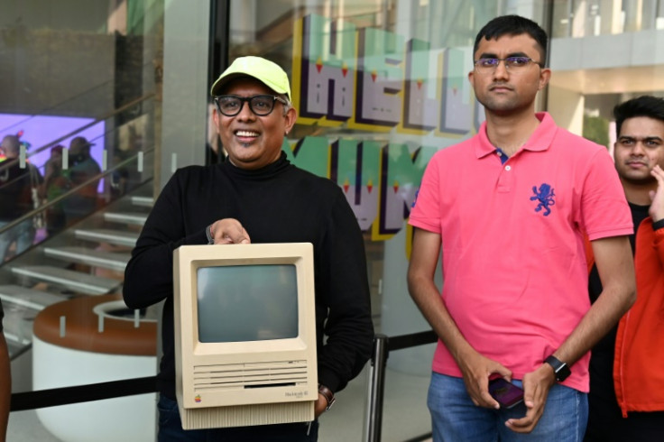 A man queueing outside India's first official Apple store shows off his vintage Macintosh computer
