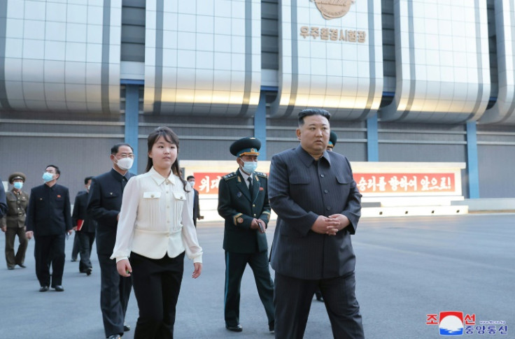 North Korean leader Kim Jong Un (R) has ordered the launch of the country's first spy satellite