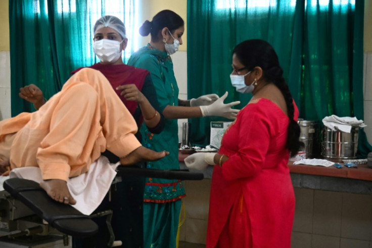 A woman lies on an operating table before tubal ligation at a health centre in Bhoodbaral in India, which UN estimates say will overtake China as the world's most populous nation by mid-year