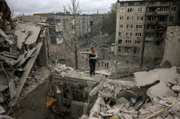 A volunteer stands on top of a partially destroyed residenial building after a shelling in Sloviansk, Donetsk region on April 14