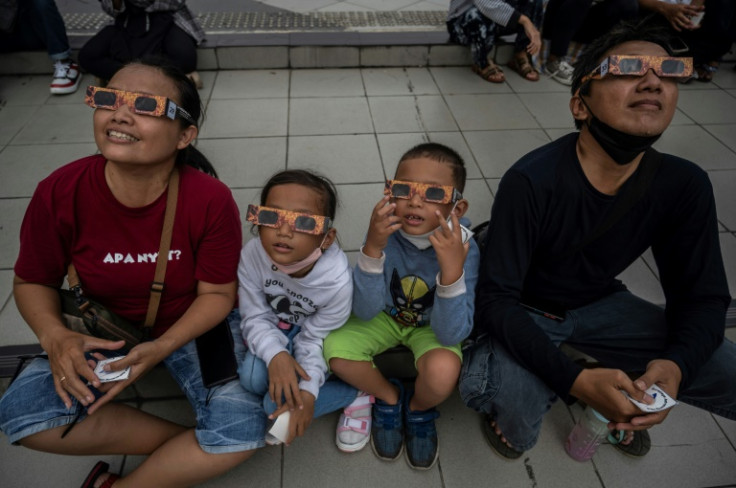 A family watches the partial solar eclipse in Surabaya, Indonesia