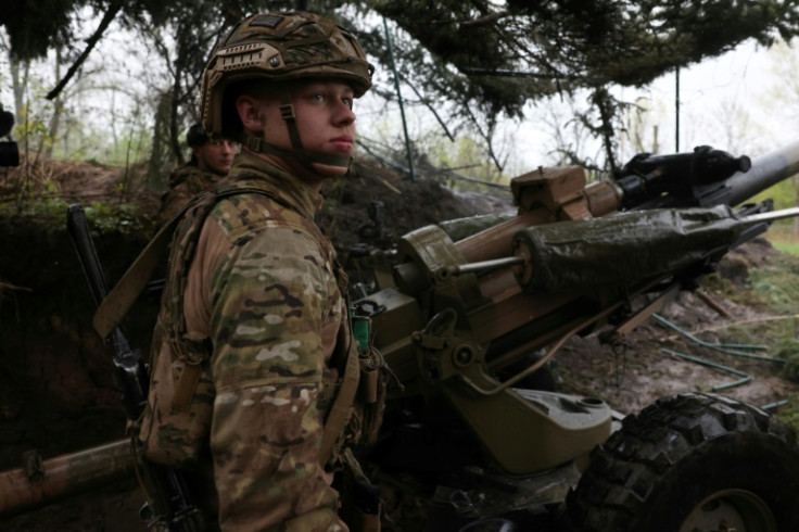 Ukrainian paratroopers fire an L119 howitzer towards Russian positions at a front line in the Lugansk region