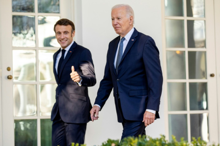 US President Joe Biden (R) and French President Emmanuel Macron walk down the Colonnade at the White House in Washington, DC, on December 1, 2022