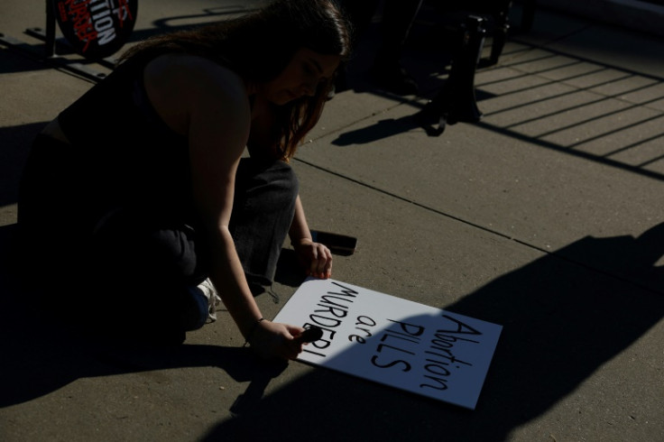 An anti-abortion activist with a sign reading 'Abortion Pills Are Murder' outside the US Supreme Court