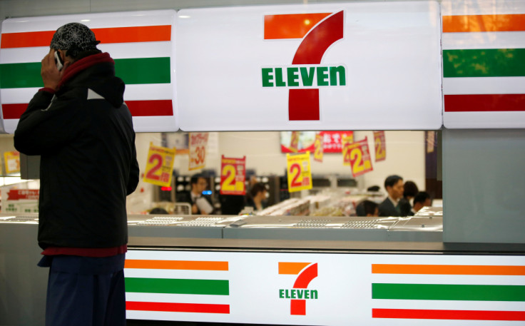 A man uses a mobile phone outside a 7-Eleven convenience store in Tokyo