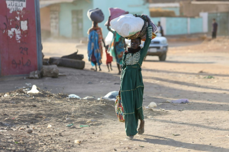 People flee fightingn between the army and paramilitaries in Khartoum on April 19