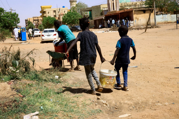 Children carry a bucket of water in Khartoum