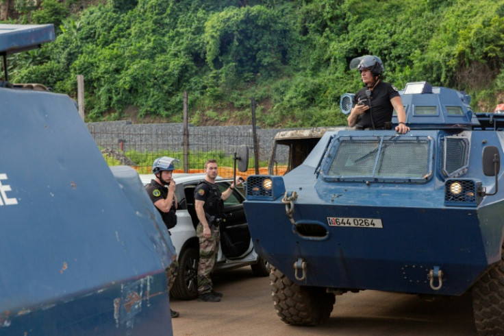 French riot police with armoured vehicles monitor the area