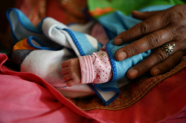 A woman holds her new grandchild at a hospital in Dehra, Himachal Pradesh. India this week eclipses China as the world's most populous country