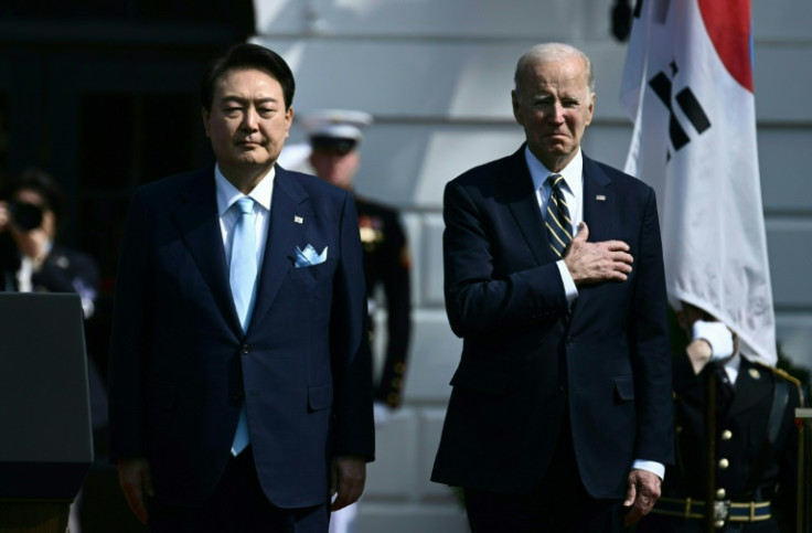 US President Joe Biden and South Korean President Yoon Suk Yeol listen to the national anthems at the White House