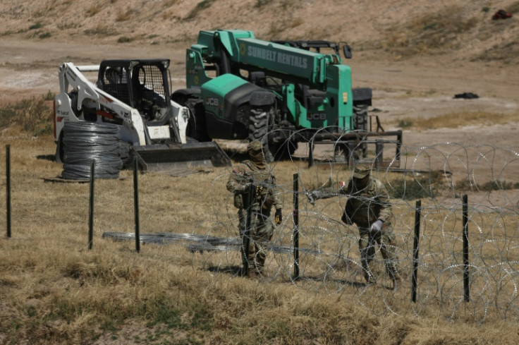 National Guard agents place a barbed wire wall on the banks of the Rio Grande in El Paso, Texas, on the border with Mexico in March 2023
