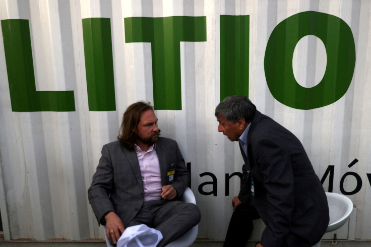 Exhibitors chat next to a signboard reading "Lithium" during a mining fair in Santiago