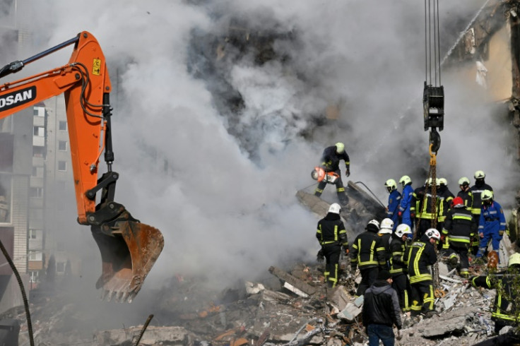 Rescuers search for survivors in the rubble next to a damaged residential building in Kyiv