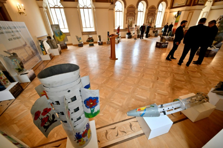 Visitors view art during the opening of an exhibition featuring decorated Russian missile fragments collected in the Kyiv region