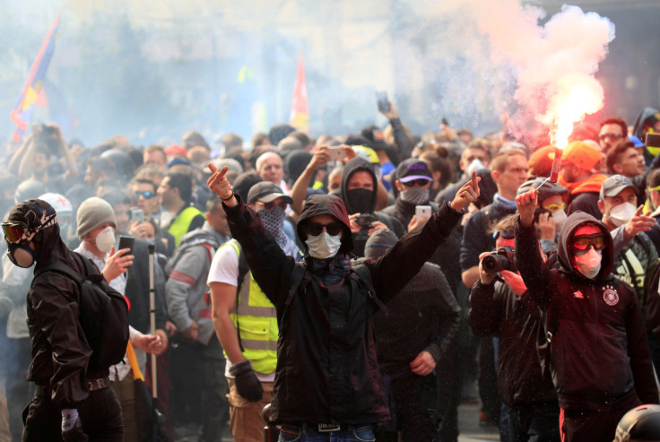 Masked protesters react during clashes with riot police as part of the traditional May Day labour union march with French unions and yellow vests protesters in Paris