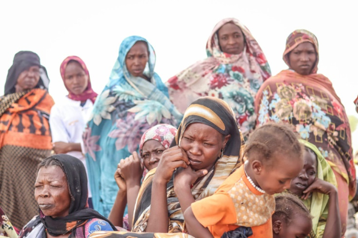 Sudanese refugees wait for a handout of aid at a makeshift camp in Koufroun