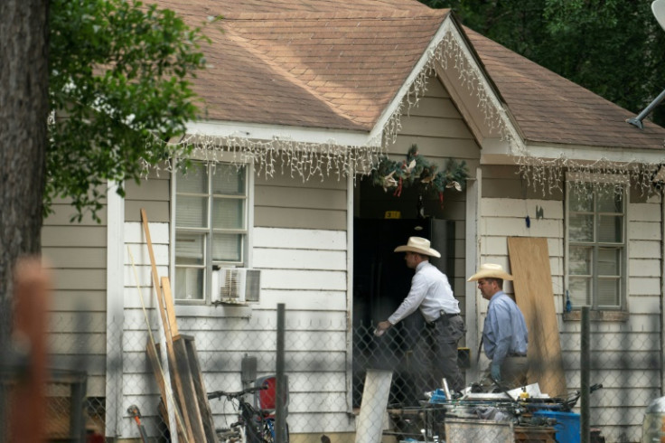 Law enforcement officers enter the house where five people, including an 8-year-old boy, were killed allegedly by a neighbor