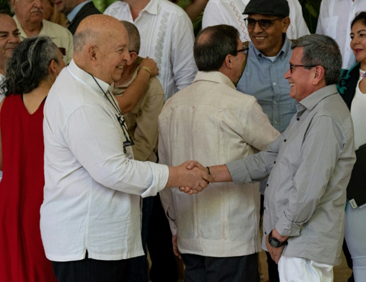 Chief Negotiator of the Government of Colombia Jose Otty Patino (L) and Colombia's National Liberation Army (ELN) guerrilla commander Pablo Beltran shake hands during peace talks in Havana