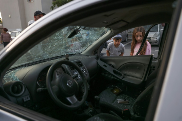 Children inspect a car damaged by Palestinian rocket fire on the Israeli town of Sderot close to the Gaza border