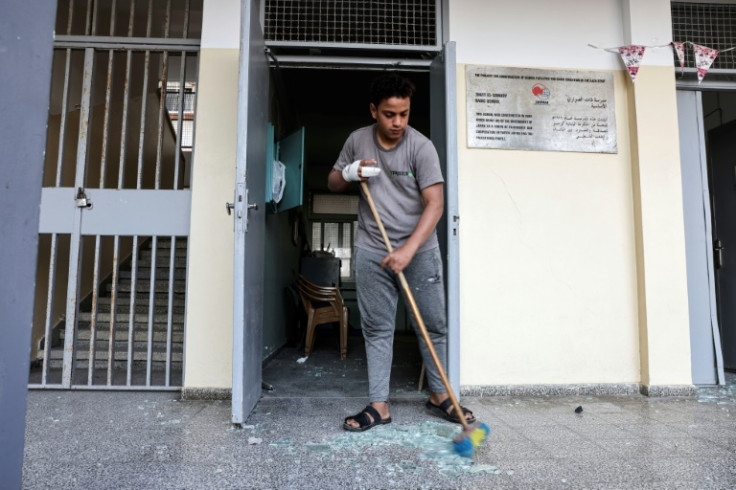 A Palestinian clears shattered glass from a school in Gaza City after Wednesday's pre-dawn Israeli air strikes
