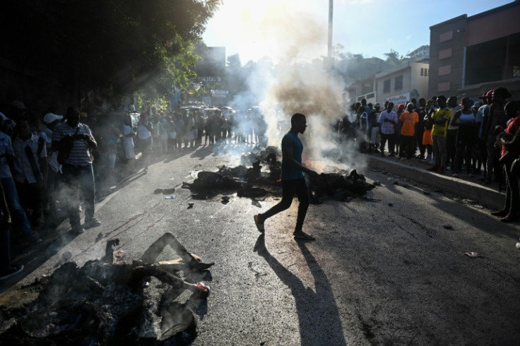 People look at bodies in the street after gang-related violence in the capital of Port-au-Prince, Haiti on April 24, 2023