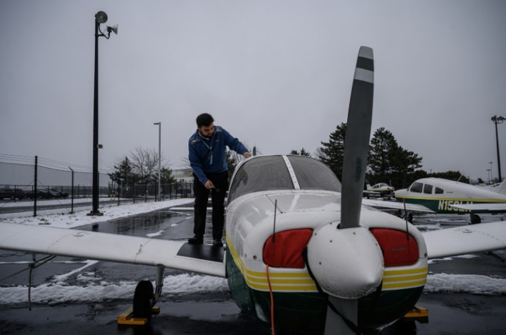 An instructor stands before training aircraft at the Farmingdale State College flying school in Farmingdale, New York