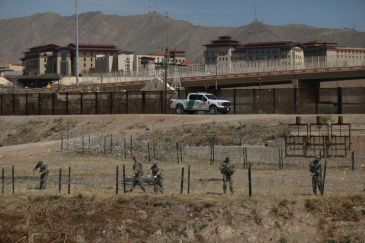 Texas National Guard personnel place barbed wire on the banks of the Rio Grande in El Paso, Texas, on the border with Ciudad Juarez