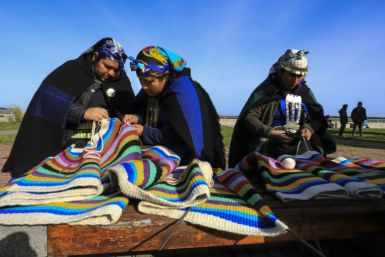 Indigenous Mapuche women of Chile weave on a loom; a new study has linked an ancient Asian lineage with the First Americans