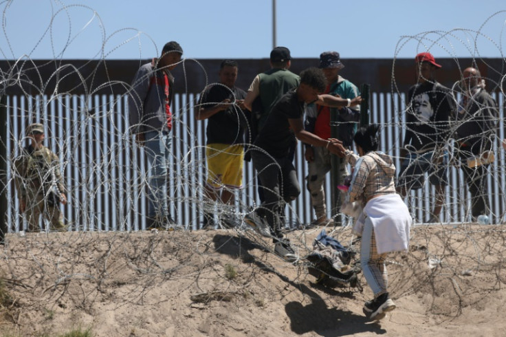 Migrant people cross the banks of the Rio Grande to be processed by the Border Patrol El Paso Sector, Texas, after crossing from Ciudad Juarez, Mexico on May 8, 2023