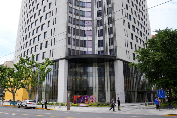 People walk past an office building, where Canada's Consulate General facilities are located, in Shanghai