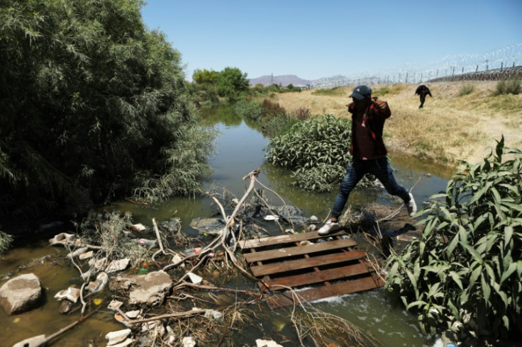 Migrants cross the Rio Grande river to be processed by US border officials in El Paso, Texas