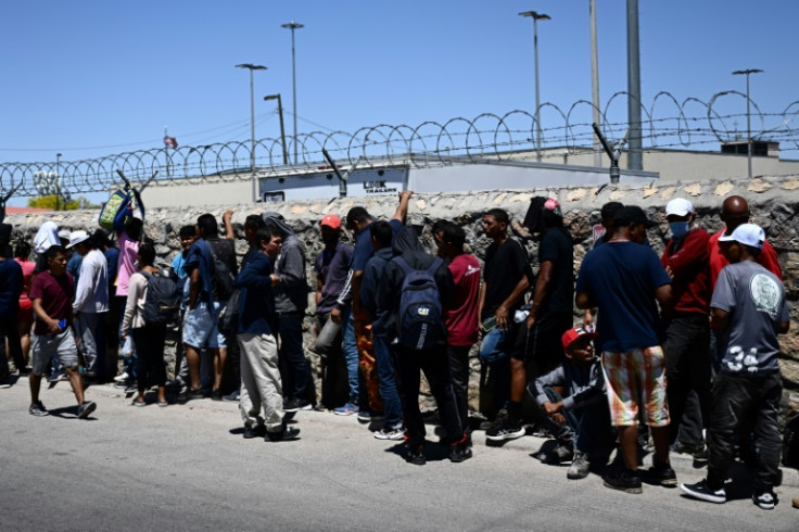 Migrants wait in line to turn themselves in for processing to US Customs and Border Protection agents in El Paso, Texas