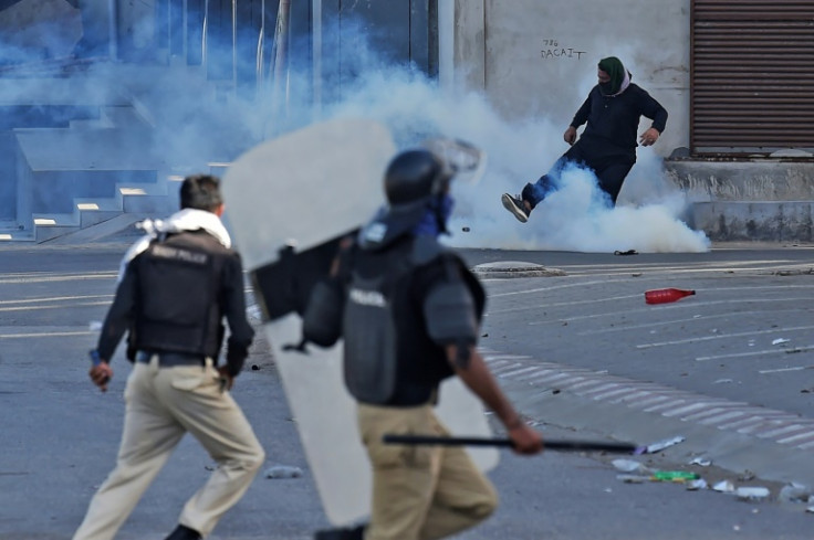 A protester kicks a tear gas cannister fired by police in Karachi, Pakistan's largest city
