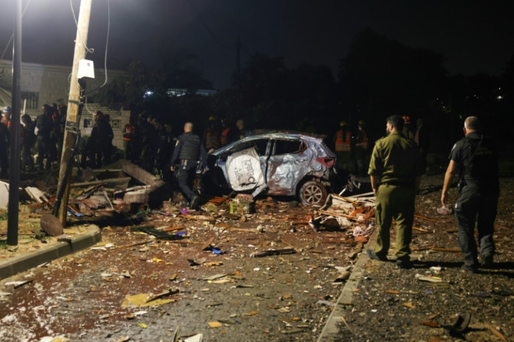 Israeli security forces and emergency rescue personnel asses the damage caused in a neighbourhood in Ashkelon by a rocket fired from the Gaza strip, on May 10, 2023