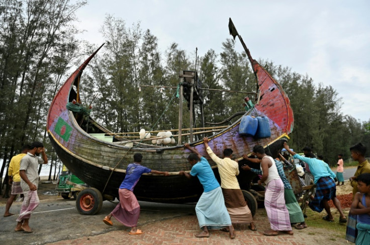 Fishermen shift a boat to a safer place in Teknaf, Bangladesh