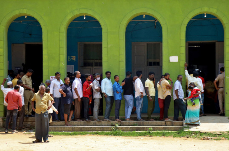 People wait in a queue to cast their vote at a polling station in Bengaluru