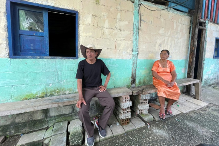 Residents sit outside a house on Puerto Libertad island near Guayaquil, Ecuador, on May 11, 2023