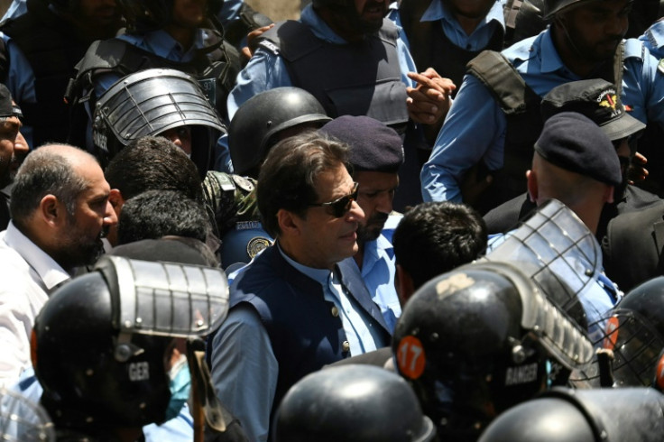 Police escort former Imran Khan (C) as he arrives at the high court in Islamabad on May 12, 2023