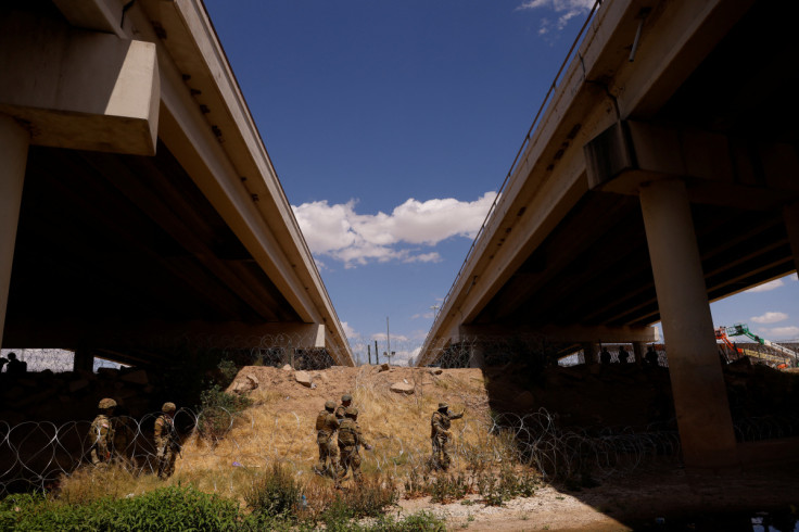 Members of the Texas Army National Guard extend razor wire to inhibit migrants crossing, as seen from Ciudad Juarez