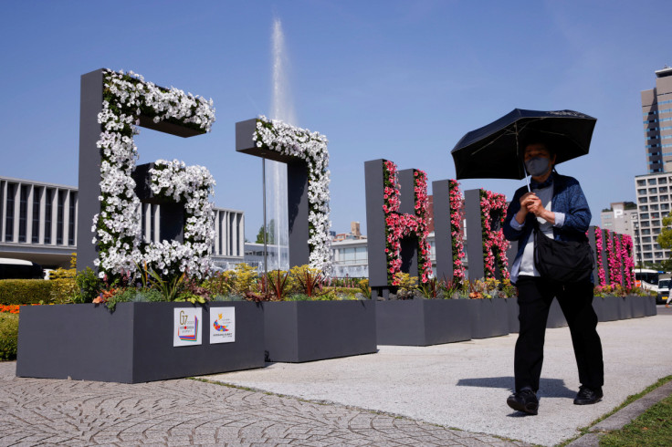 Woman walks past a “G7 Hiroshima” flower installation near the Peace Memorial Museum, ahead of the G7 summit, in Hiroshima