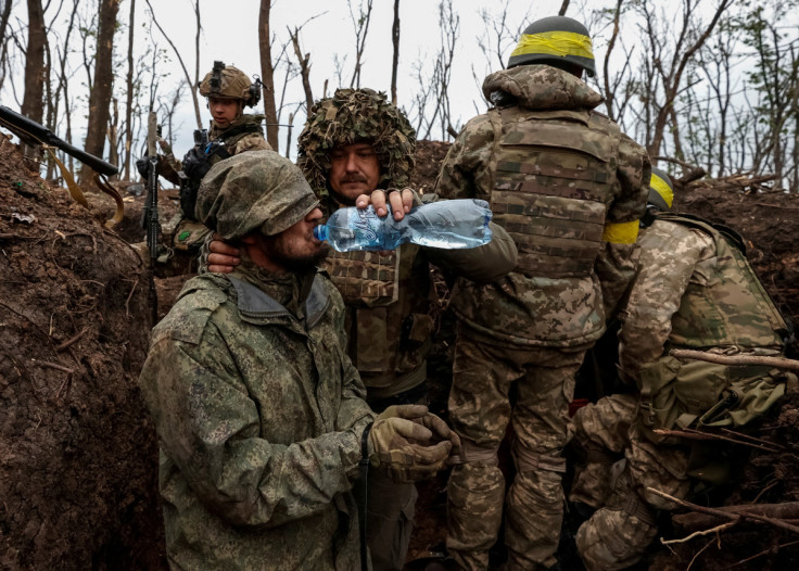 A Ukrainian soldier gives waterto a captured Russian army serviceman near the front line city of Bakhmut