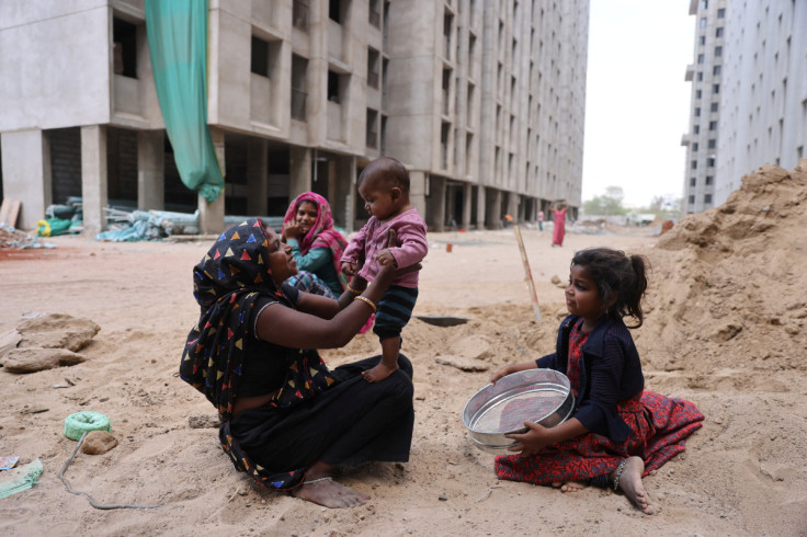 Heena Parmar plays with her son Vaibhav as her daughter Sonal looks on at a construction site in Ahmedabad