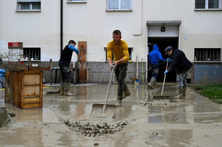 Volunteers clean mud from a flooded courtyard in Faenza, after floodwaters hit the Emilia-Romagna region