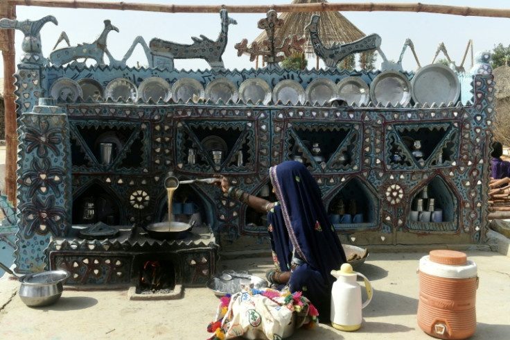 Dhani Khomo, who trains others to make earthen stoves lifted off the floor, prepares tea at her open kitchen in Pono Colony at Sanjar Chang village, in Tando Allahyar district